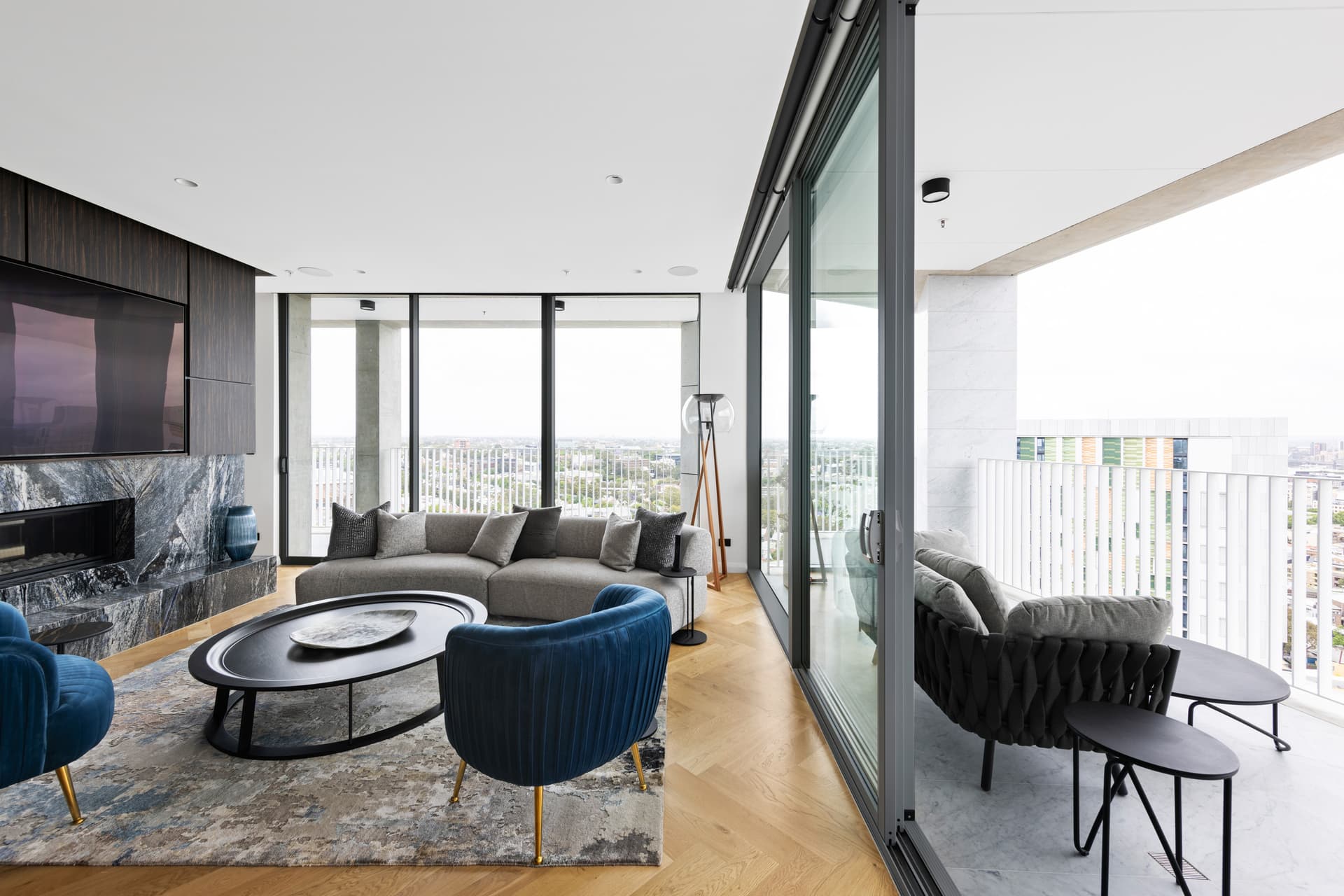 Living room opening onto a balcony through large aluminium sliding doors